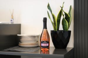 a bottle of wine sitting on a table with a plant at Dadu Rooms in Orikum