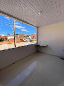 an empty room with a large window with a view at Casa 3 quartos 6 pessoas garagem in Coração de Jesus