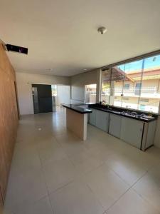 a large kitchen with a counter in a large room at Casa 3 quartos 6 pessoas garagem in Coração de Jesus