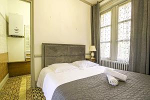 a bedroom with a bed and a large window at La Villa Bligny in Étretat