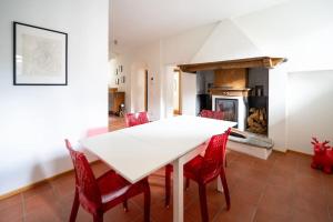 a dining room with a white table and red chairs at Charme Maison - Ticino - YouStay in Mendrisio
