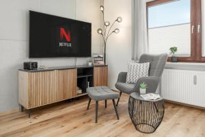 a living room with a tv and two chairs and a table at FENJOY Design Studio Apartment in Bernau am Chiemsee