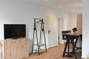 a living room with a television on a stand and a table at Apartment Grone 2 in Göttingen
