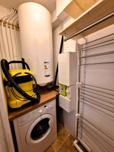 a laundry room with a washing machine and a washer at Studio LILAS avec terrasse au calme in Montreuil