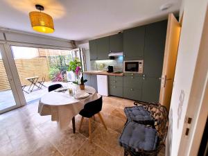 a kitchen and dining room with a table and chairs at Studio LILAS avec terrasse au calme in Montreuil