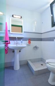 a bathroom with a sink and a toilet and a mirror at Milos Studios in Malia