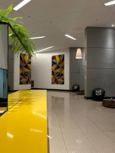 a yellow floor in a room with paintings on the wall at Luxury Paiva Flat in Recife +33 photos