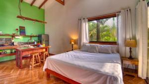 um quarto com uma cama branca e uma parede verde em Casa jessica em Hone Creek