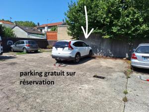 Une voiture blanche est garée sur une place de parking gratuite réservée au soleil. dans l'établissement Studio LILAS avec terrasse au calme, à Montreuil