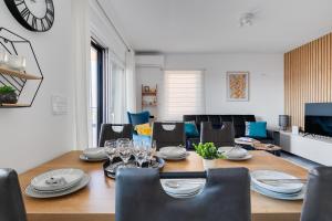 a dining room with a table and chairs and a clock at Sea Bay View apartment - Appartement avec piscine et magnifique vue sur mer in Sveti Filip i Jakov