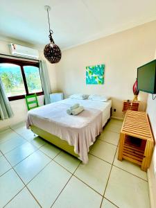 a bedroom with a bed and a tv in it at Parcel do Gostoso Pousada in São Miguel do Gostoso