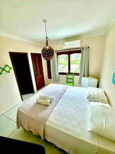 a bedroom with a large bed with two towels on it at Parcel do Gostoso Pousada in São Miguel do Gostoso