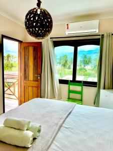 a bedroom with a large bed with a large window at Parcel do Gostoso Pousada in São Miguel do Gostoso