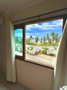 a window in a room with a view of a beach at Parcel do Gostoso Pousada in São Miguel do Gostoso +82 photos