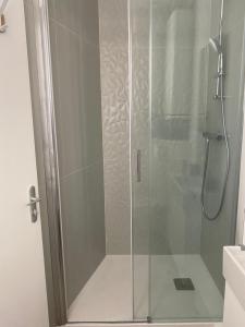 a shower with a glass door in a bathroom at Studio centre ville proche RER A wifi in Saint-Germain-en-Laye