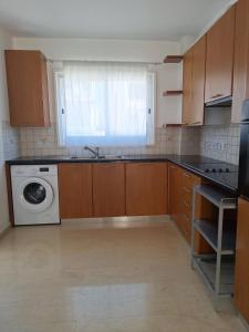 a kitchen with a sink and a washing machine at City Sunshine, Strovolos - Nicosia in Nicosia