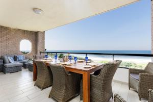 a dining room with a table and chairs at Summer Rocks 10 in Uvongo Beach