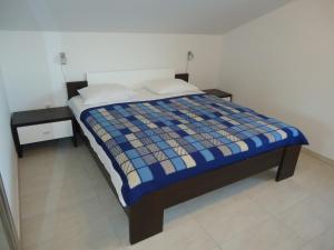a bedroom with a bed with a blue comforter at Holiday Home Sisko in Trogir