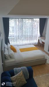 a bedroom with a bed and a large window at Executive Studio Apartment in Kilimani, Nairobi in Nairobi