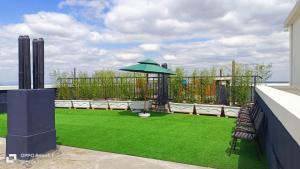 a patio with a green lawn and an umbrella at Executive Studio Apartment in Kilimani, Nairobi in Nairobi