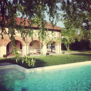 a house with a swimming pool in front of it at La Scuderia Charming Rooms in San Paolo Solbrito