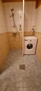 a washing machine in a bathroom with a shower at Tahko Hovimäenraitti 5A in Tahkovuori +16 photos