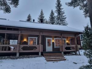 a log cabin in the snow with a porch at Tahko Hovimäenraitti 5A in Tahkovuori