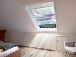a bedroom with a window and a bed and a chair at Apartment in Sallneck near Nonnenmattweiher Lake in Sallneck