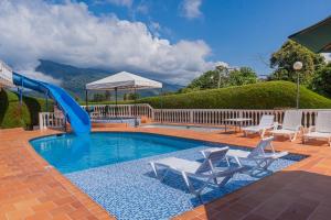 a pool with a slide and chairs and a slide at Lago Calima - Bella Finca in Madroñal