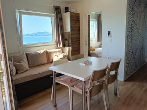 a living room with a white table and a couch at Mobile home Greta in Klenovica