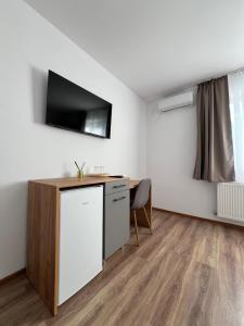 Una habitación con un escritorio y un televisor en la pared. en Salin Home, en Ocna-Mureşului