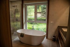 a large white tub in a bathroom with a window at Edelweiss Lodge in Hohentauern +84 photos