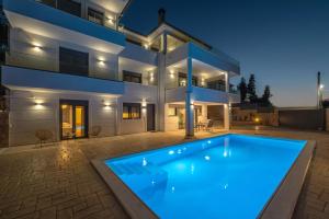 a large swimming pool in front of a house at Serenitas in Kalamos