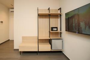 a room with a wall with shelves and a tv at ReiVal Hotel Marina Vlore in Vlorë