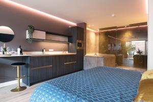 a bedroom with a bed and a kitchen with a sink at Suite-Elegance privé sauna & jacuzzi in The Hague