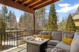 a patio with a couch and a fire pit on a deck at Oak Mountain Retreat, Hot Tub, & BBQ, Game Room! in Lake Arrowhead