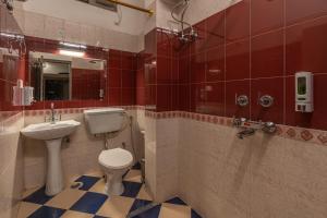 a bathroom with a toilet and a sink at Madpackers Rishikesh Laxman Jhula in Rishīkesh +29 photos