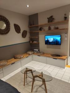 a living room with a tv on a wall at Kaz'détente, Marie Galante, plage Kawann in Grand-Bourg