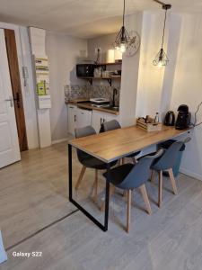 a kitchen and dining room with a wooden table and chairs at Studio tout confort proche des thermes in Vals-les-Bains