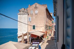 un edificio en una calle junto al océano en La Riva Luxury Rooms, en Rovinj