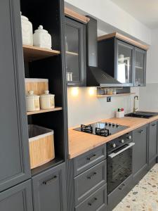 a kitchen with gray cabinets and a wooden counter top at Villa Hidden Heaven in Donje Vinovo