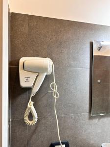 un telefono bianco appeso a un muro in bagno di Welcome to I Colori di Napoli a Napoli Altre 27 foto