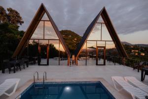 a view of a swimming pool with a sunset in the background at Darchi • დარჩი in Batumi