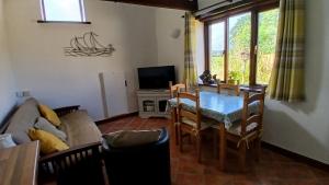 ein Wohnzimmer mit Tisch und Fernseher in der Unterkunft Hazel Cottage, Frithelstock in Frithelstock