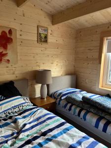 una camera con 2 letti in una baita di tronchi di Bridgets Log Cabin a Togher