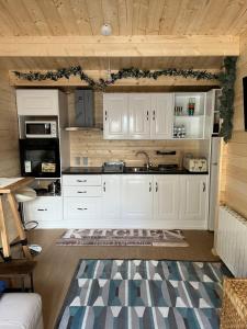 una cucina con mobili bianchi e un forno a piano cottura di Bridgets Log Cabin a Togher