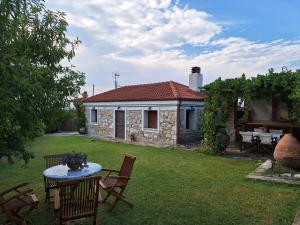 a house with a table and chairs in a yard at Garden House KRISTI in Possidi