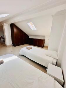 a hotel room with two beds and a chair at Casa do Mar Cascais in Alcabideche +23 photos