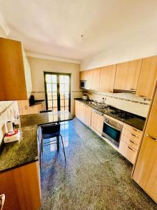 a kitchen with wooden cabinets and a counter top at Casa do Mar Cascais in Alcabideche