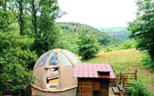 una tenda appoggiata su una piattaforma di legno in un campo di Le Mobil'Dôme à Marie a Cambounès